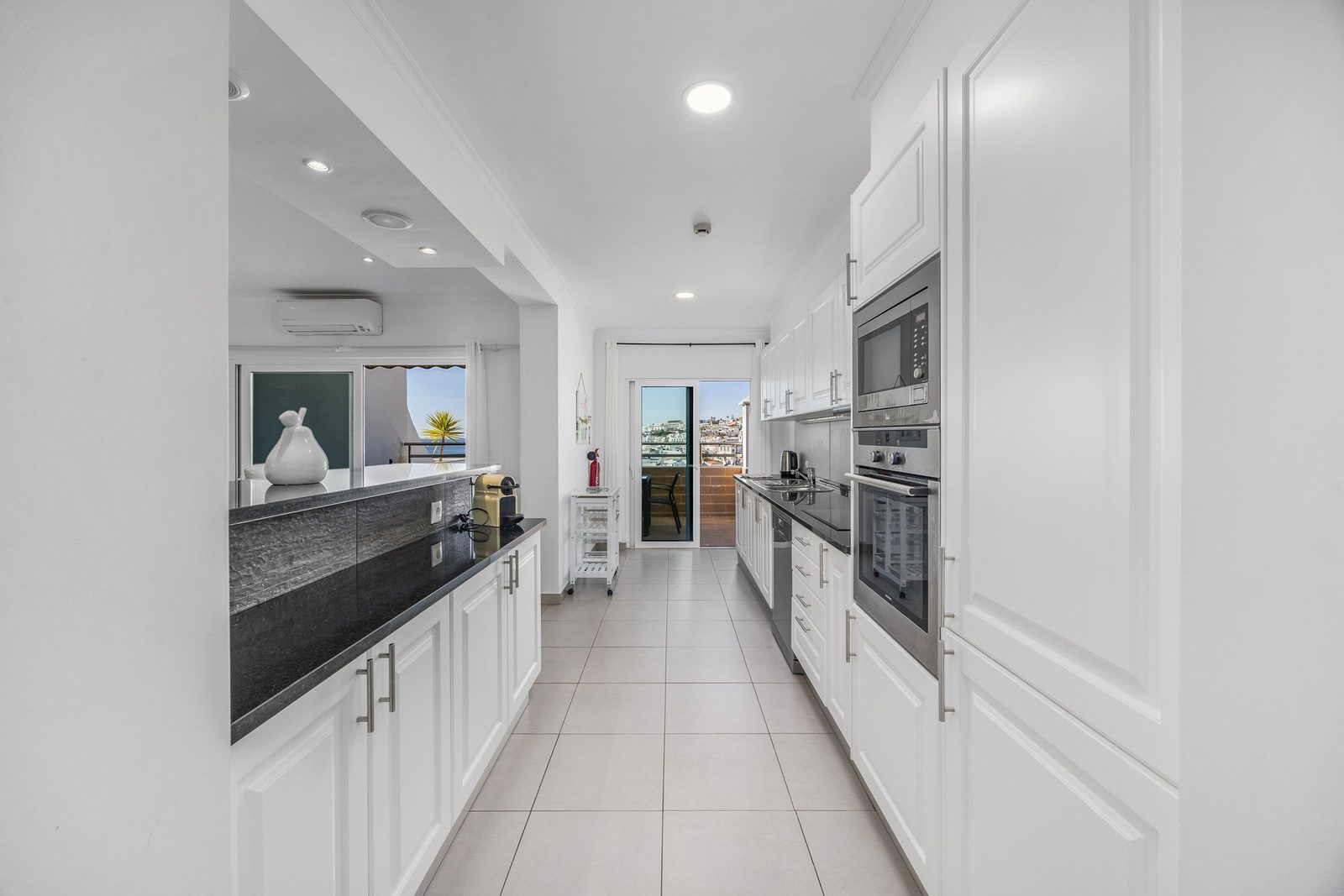 Galley kitchen with balcony access and sea view