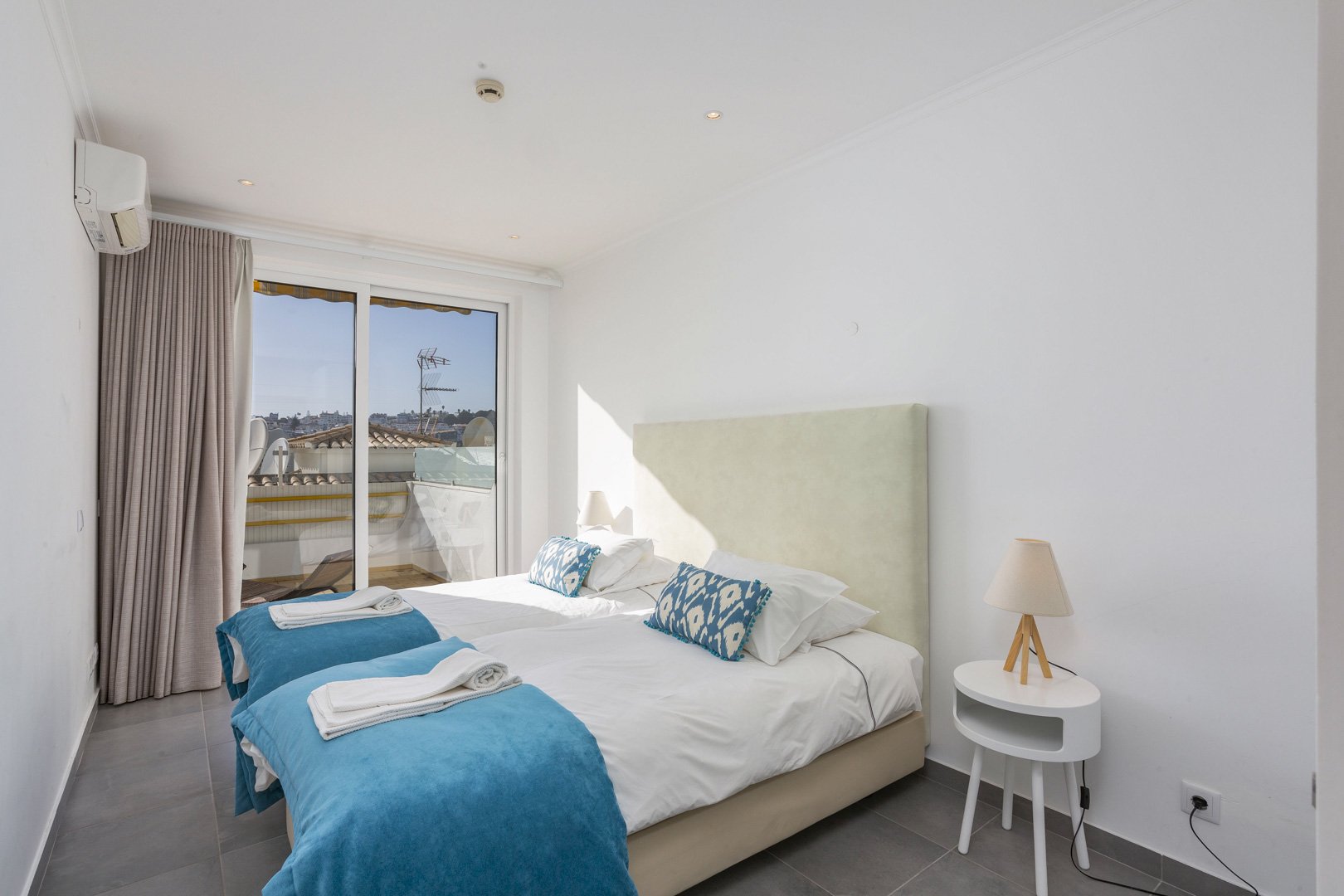 Twin bedroom with balcony access and town view