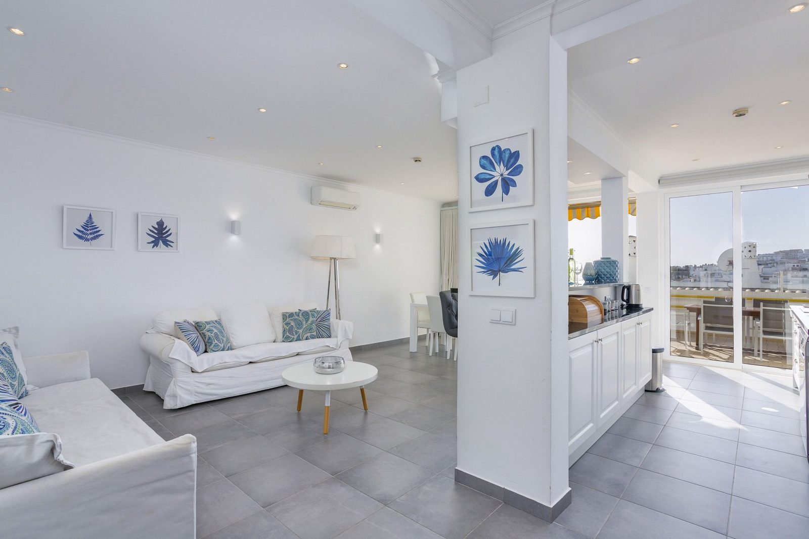 Living room with kitchen and balcony access