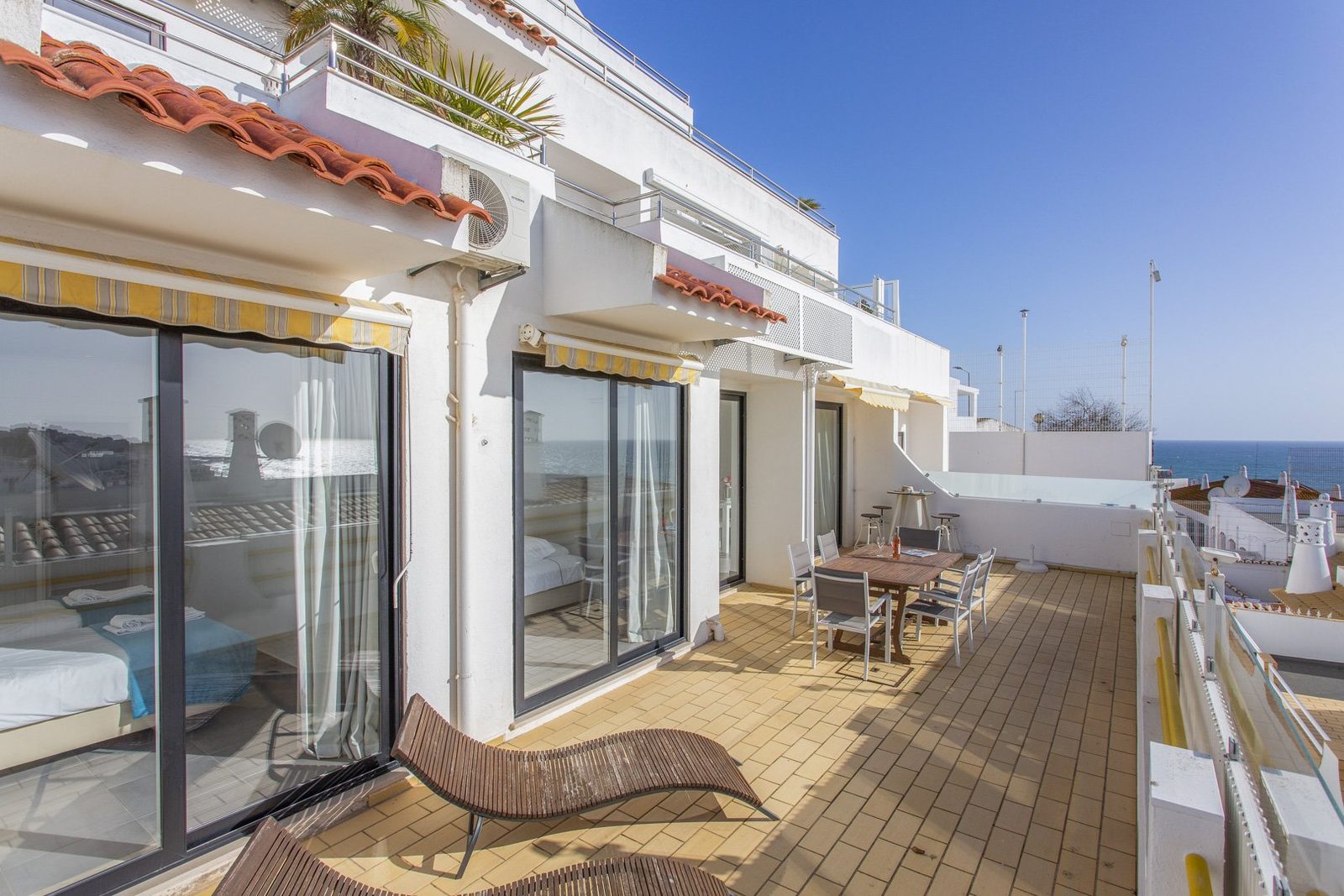 Terrace with sun loungers and dining table