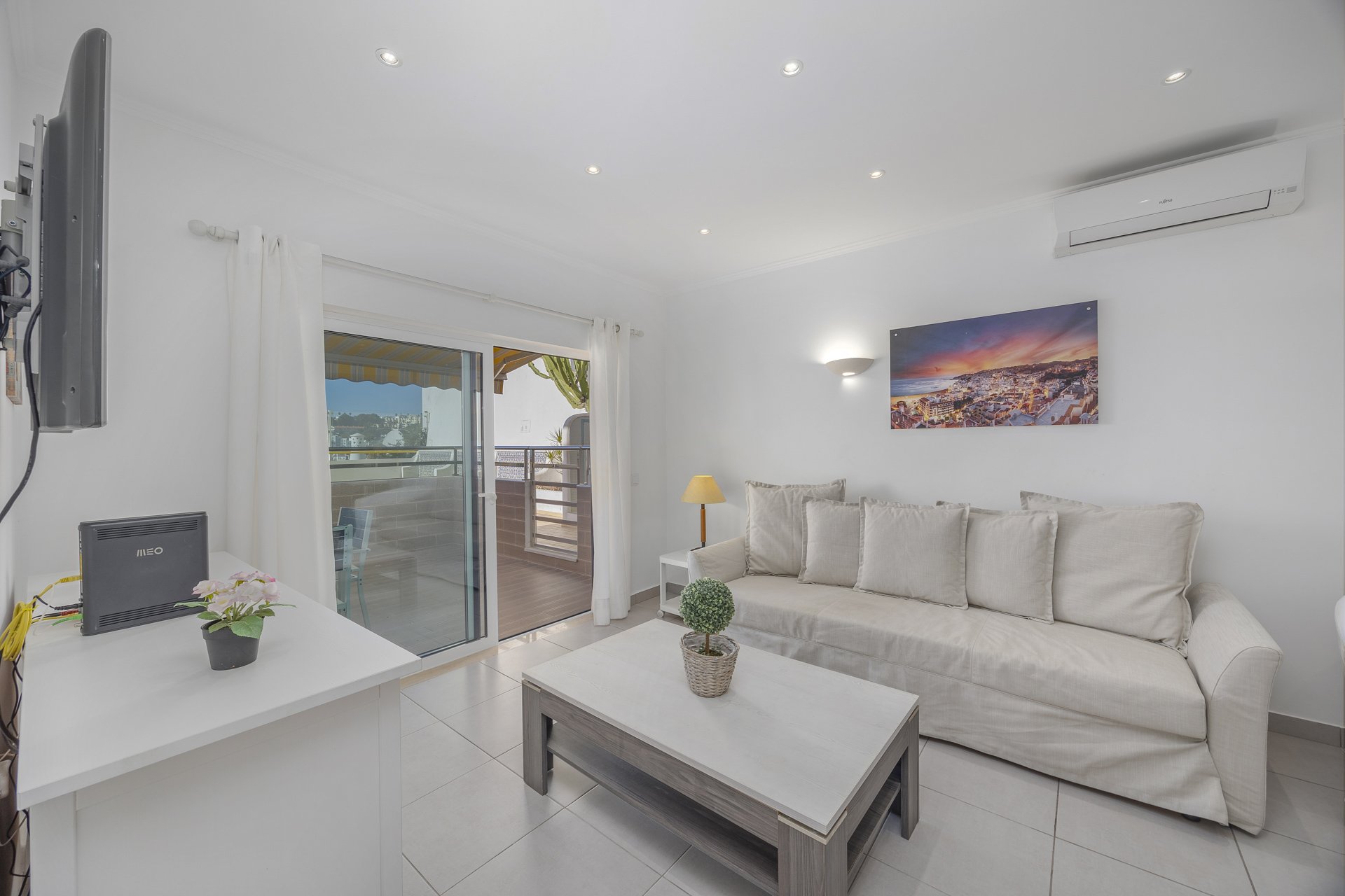 Living room with TV and balcony access, alternate view