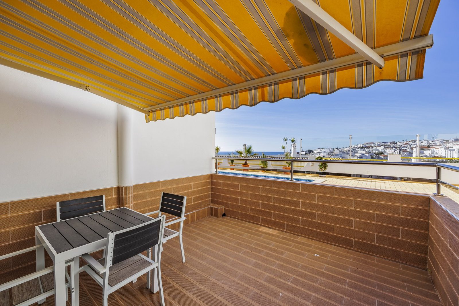 Terrace with dining table and pool view