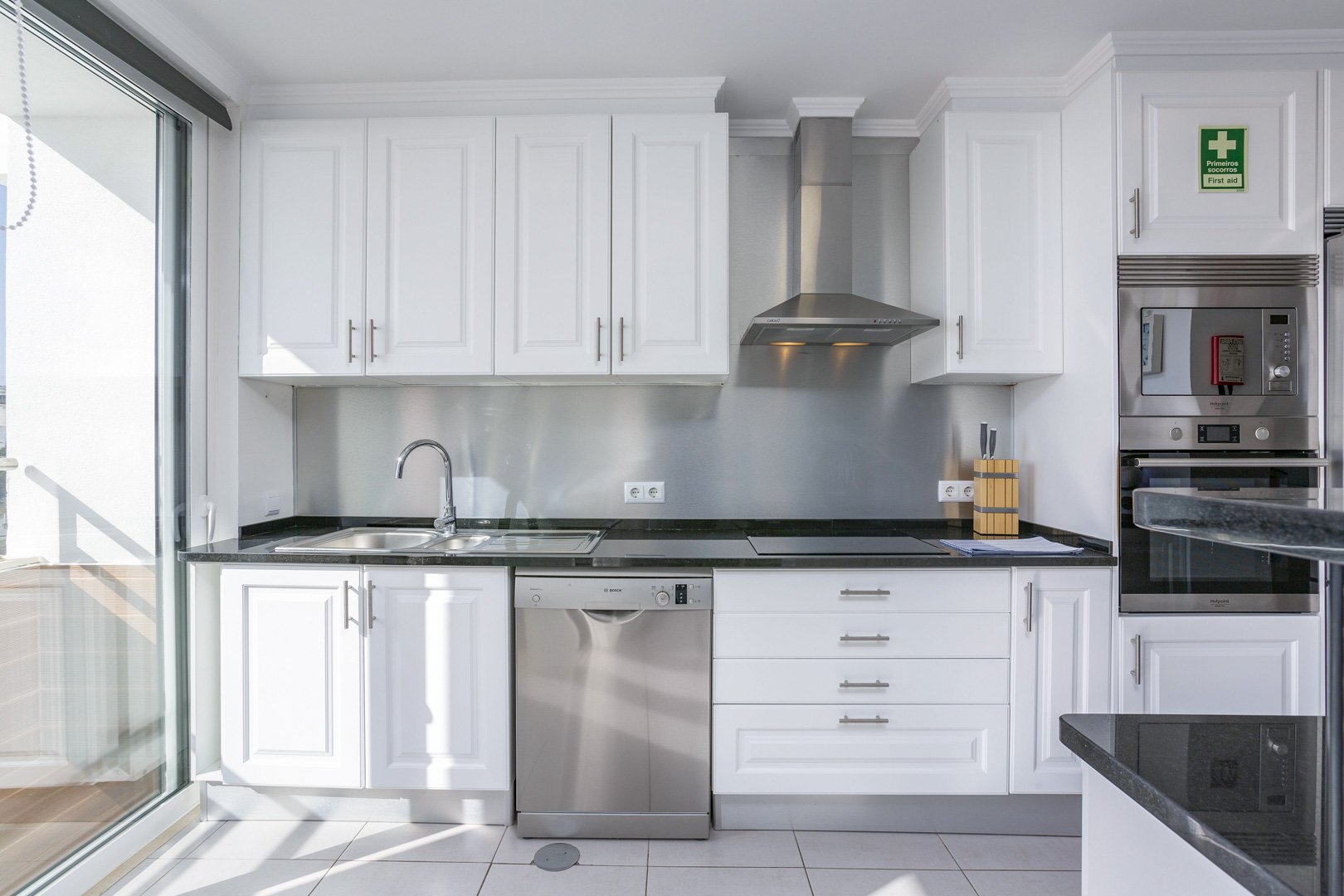 Kitchen with white cabinetry and extractor hood
