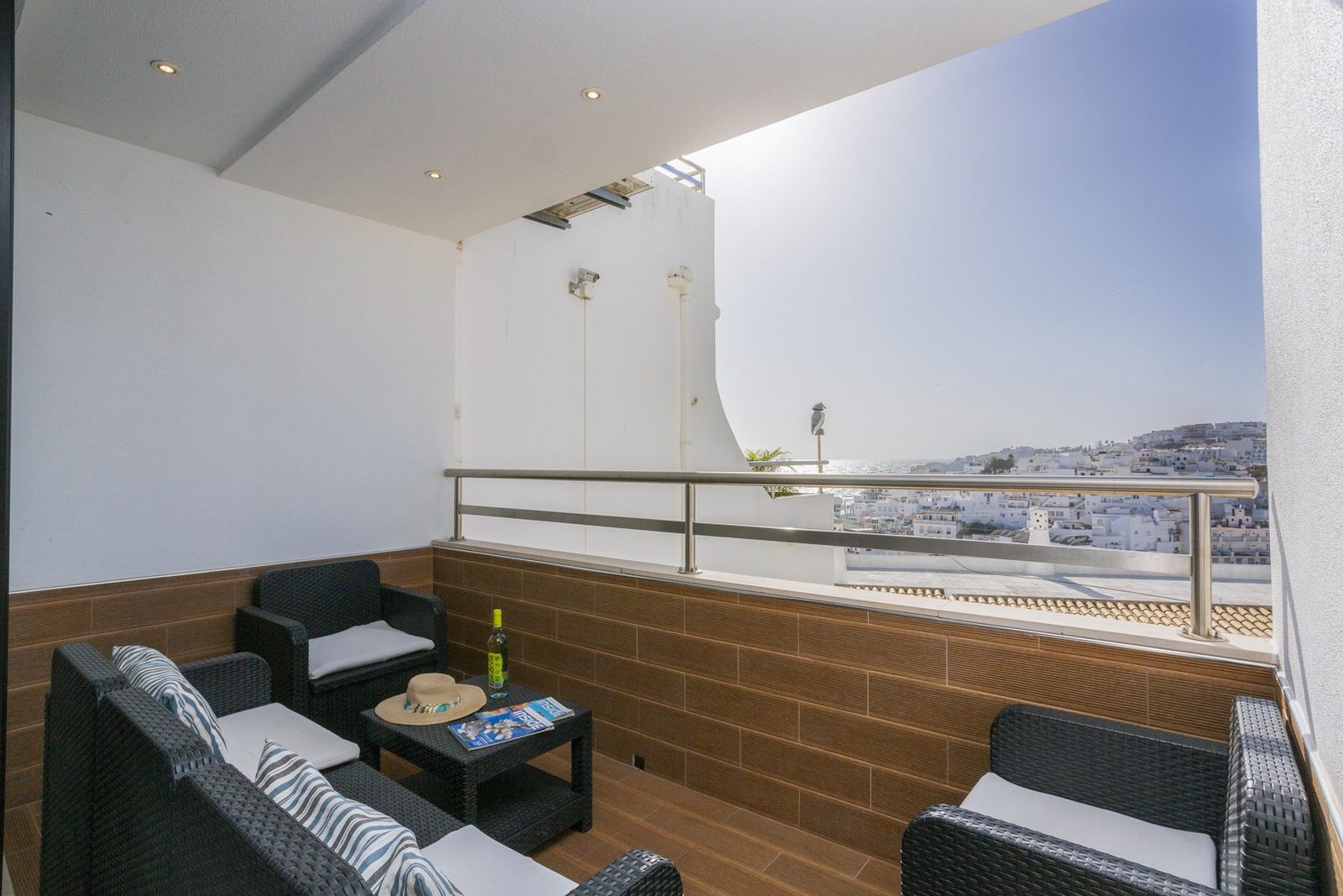 Balcony seating area with wicker furniture and sea view