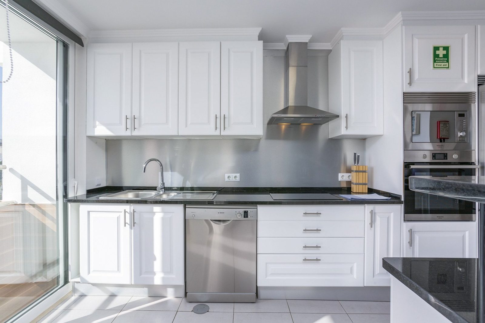 Kitchen with white cabinetry and extractor hood