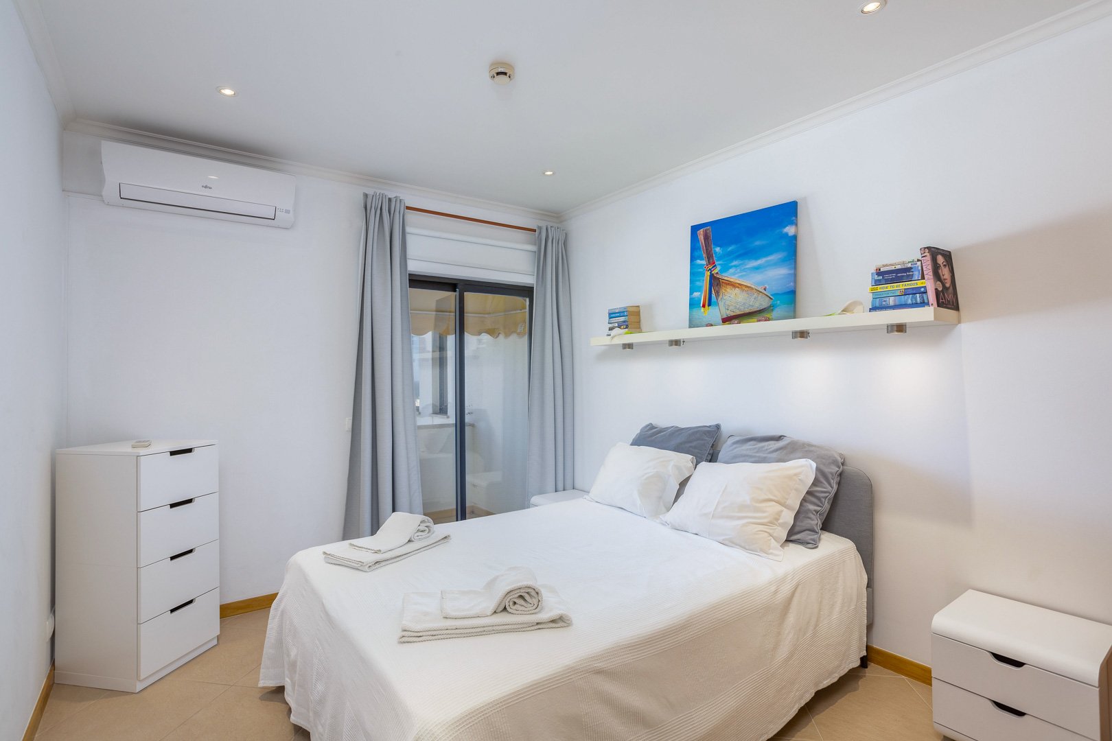 Bedroom with balcony access and decorative artwork, alternate view