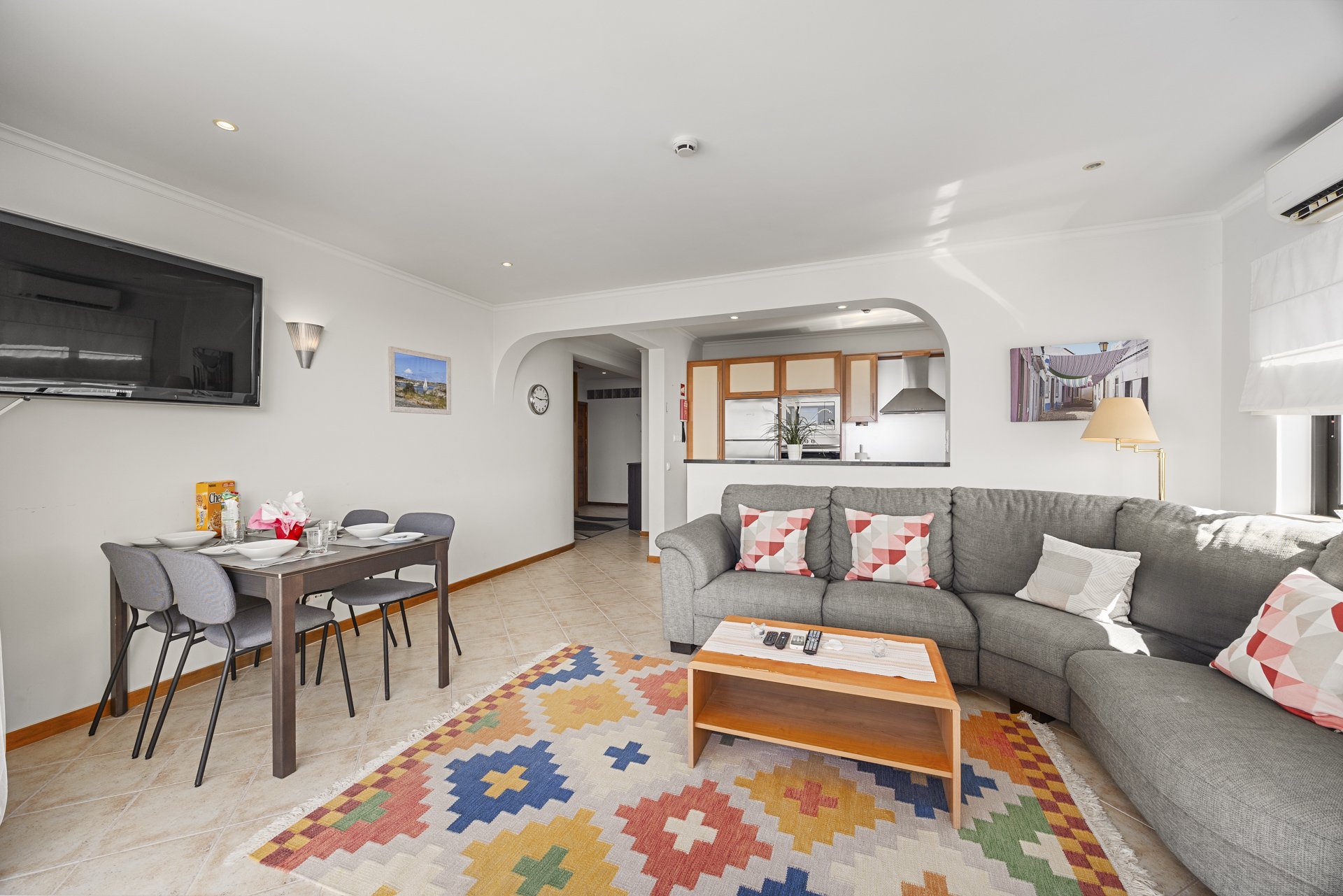Living room with TV, dining table, and colourful rug
