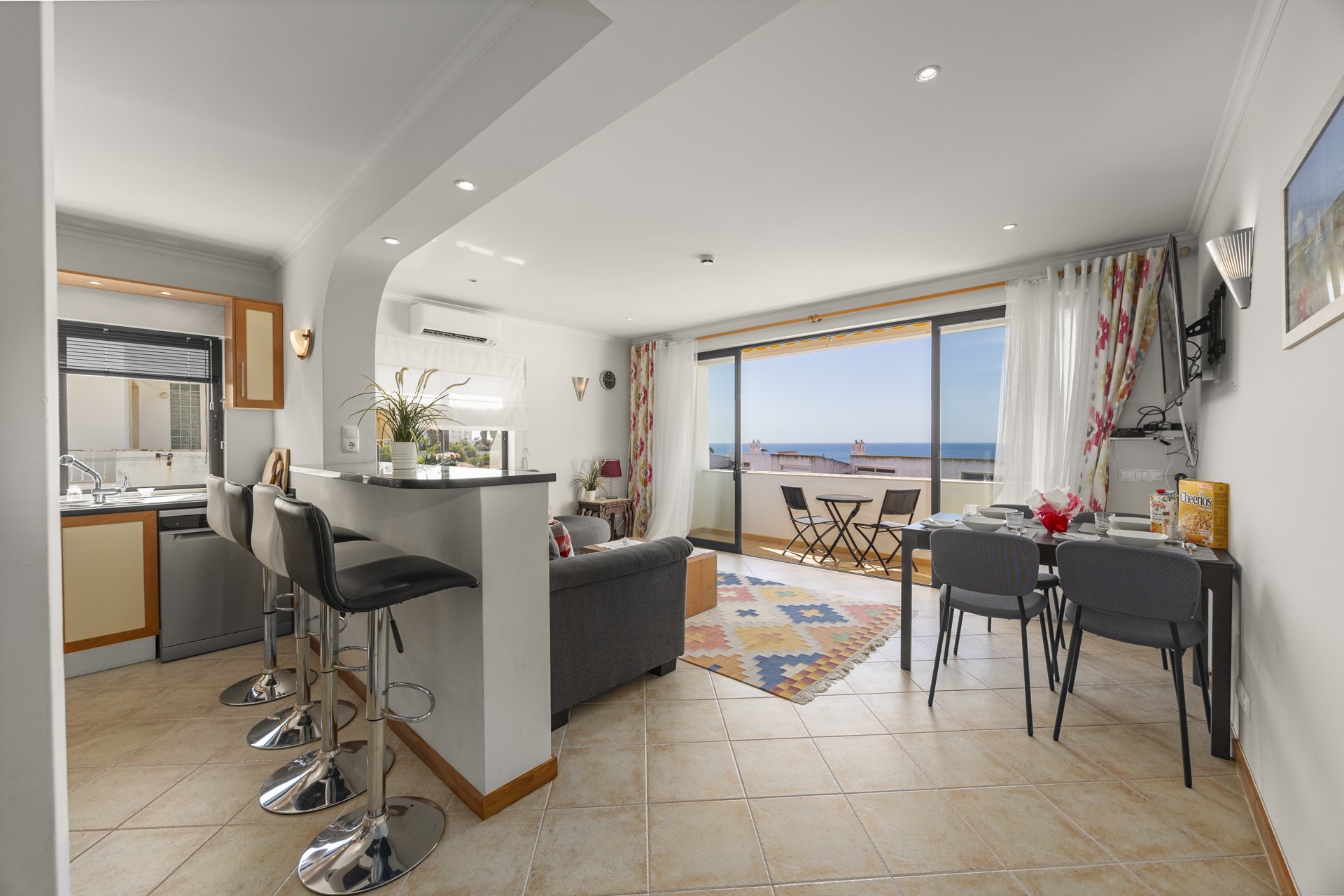 Open-plan living, dining, and kitchen area with balcony access