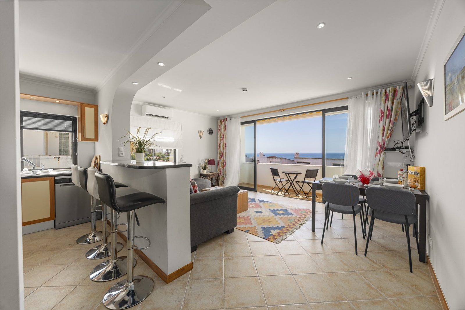 Open-plan living, dining, and kitchen area with balcony access