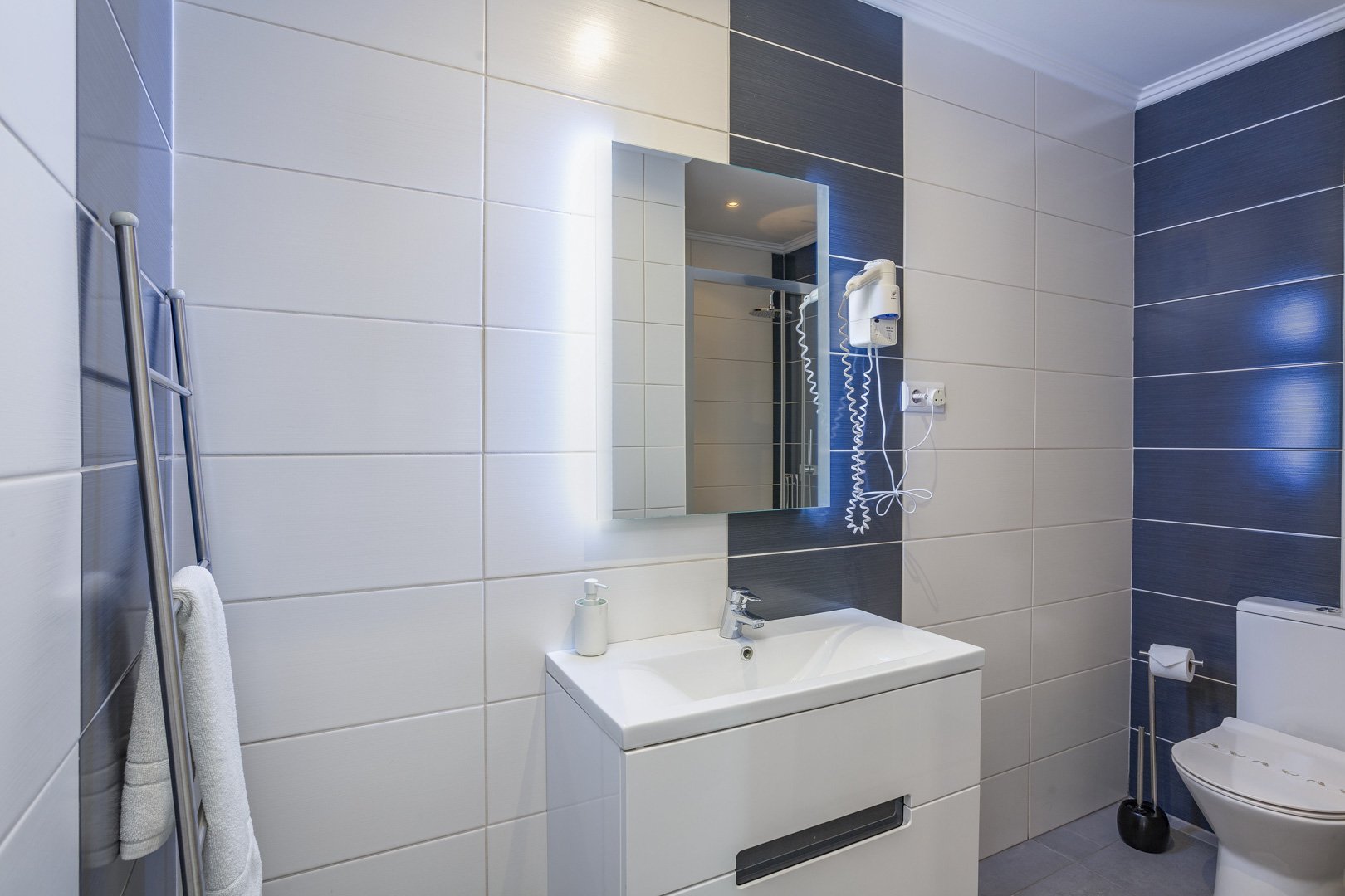 Bathroom with vanity sink, mirror, and toilet