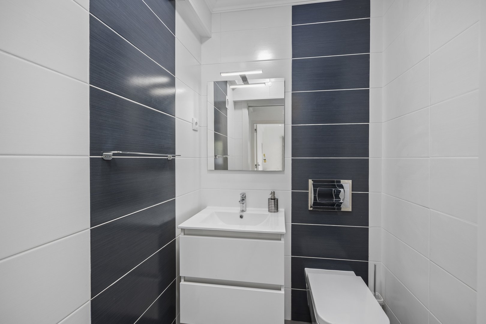 Bathroom with navy accent tile and vanity sink