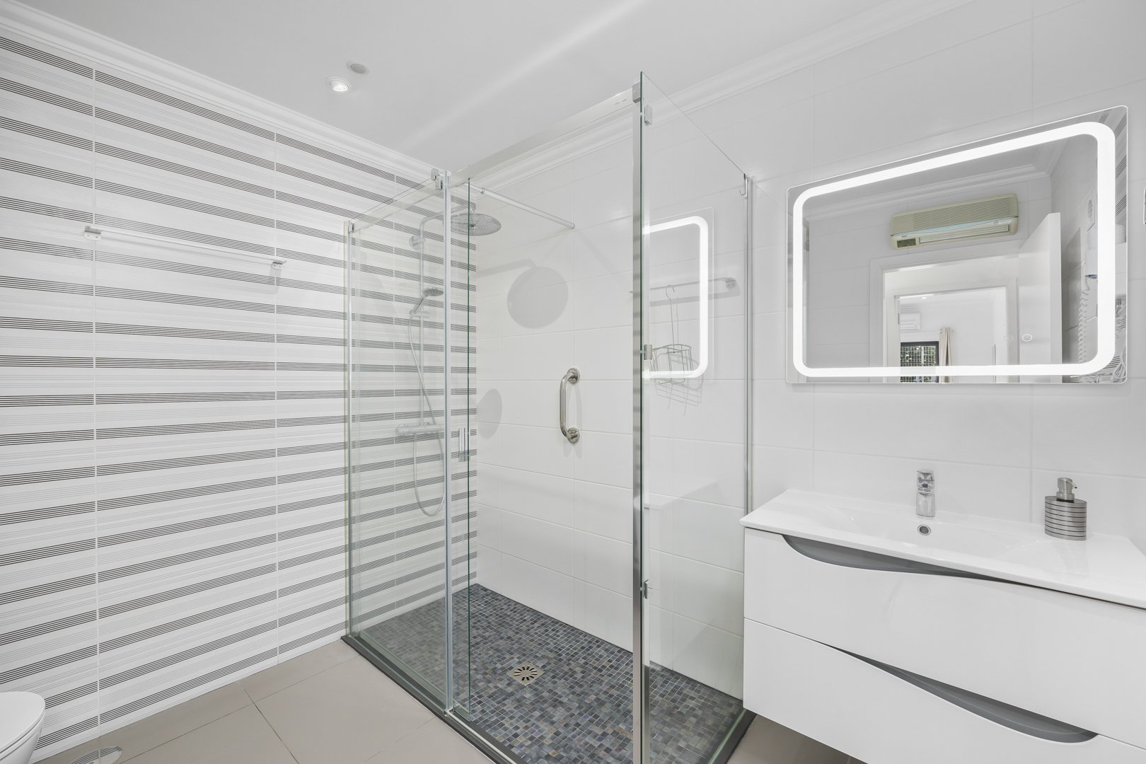 Ensuite bathroom with walk-in glass shower and illuminated mirror