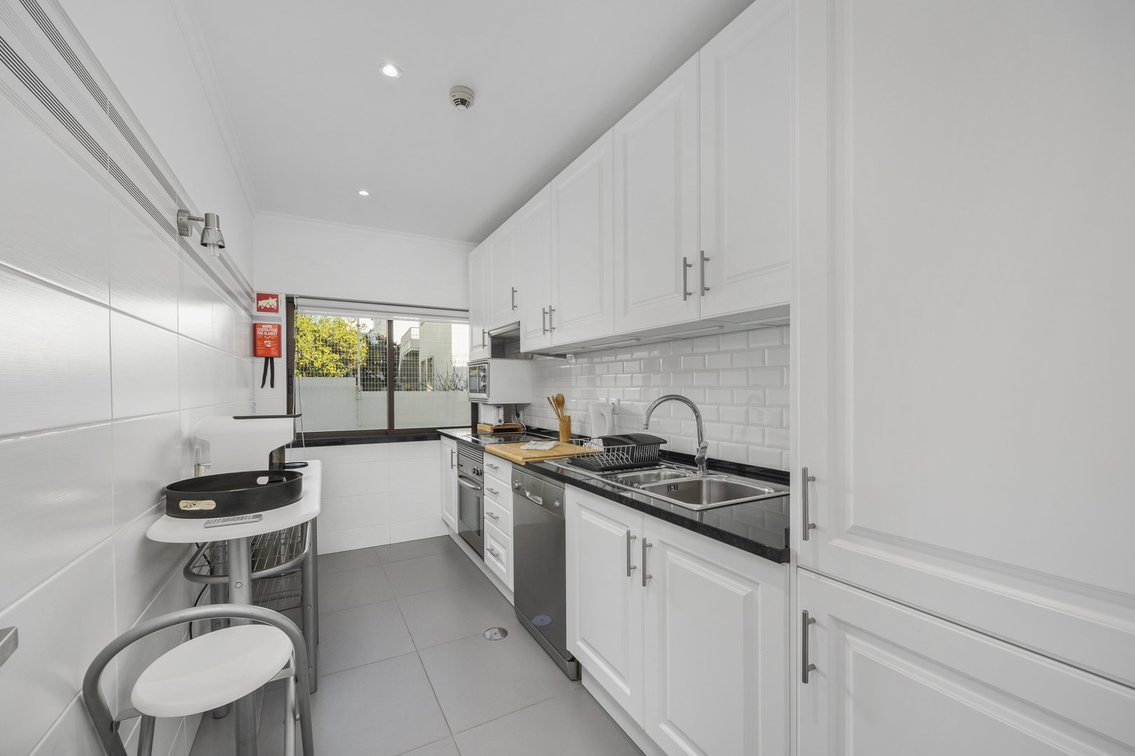 Galley kitchen with white cabinetry