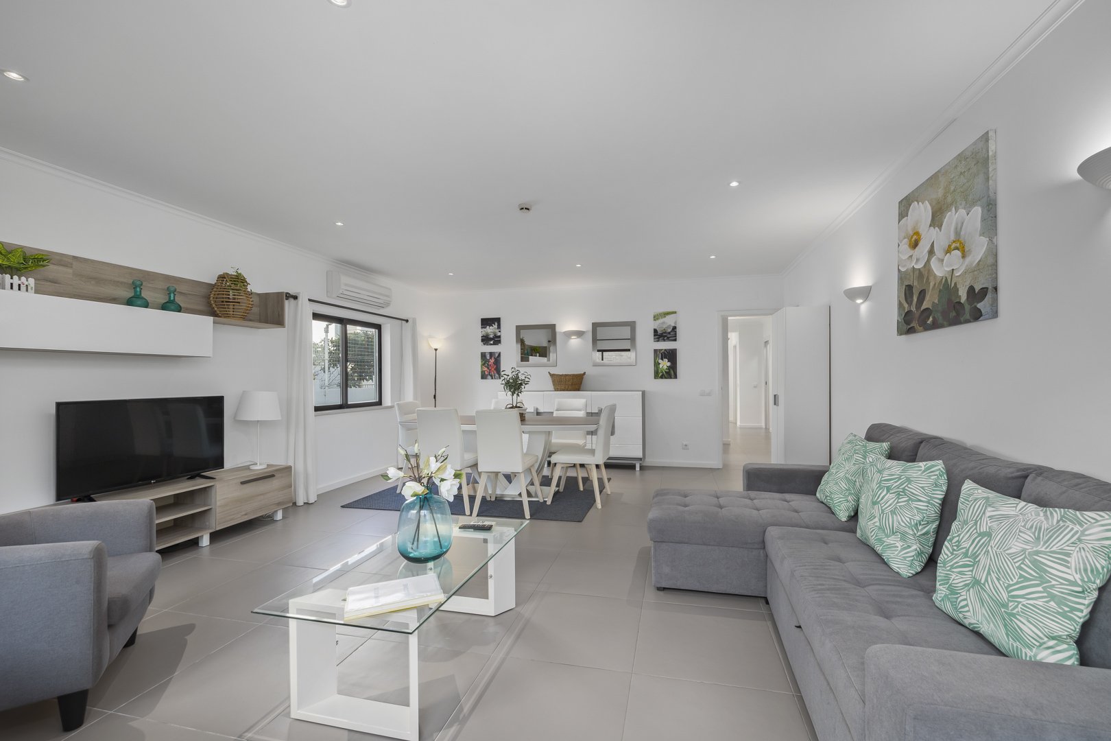 Living room with sofa, TV, and dining area beyond