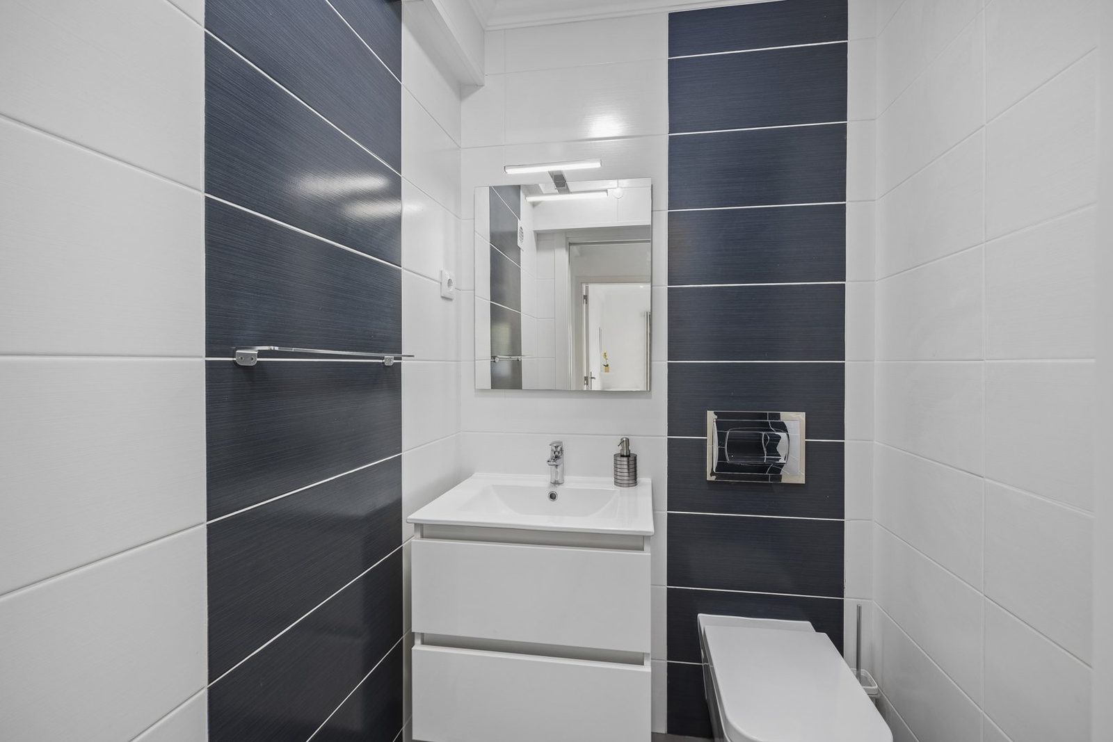 Bathroom with navy accent tile and vanity sink
