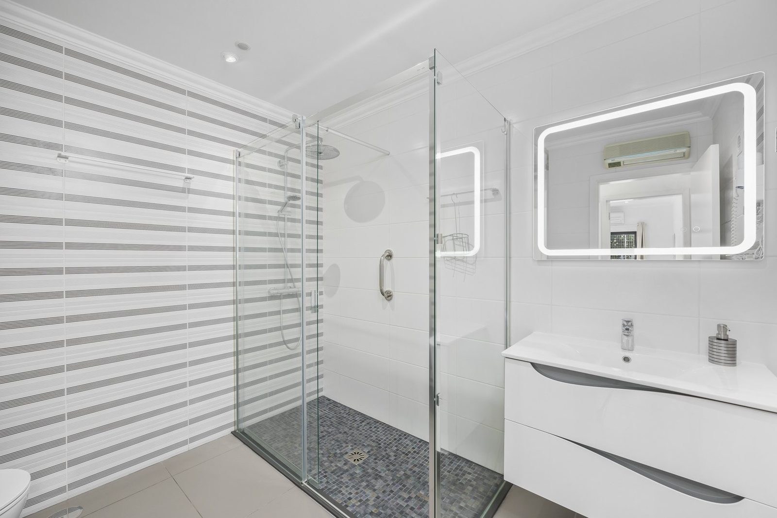 Ensuite bathroom with walk-in glass shower and illuminated mirror