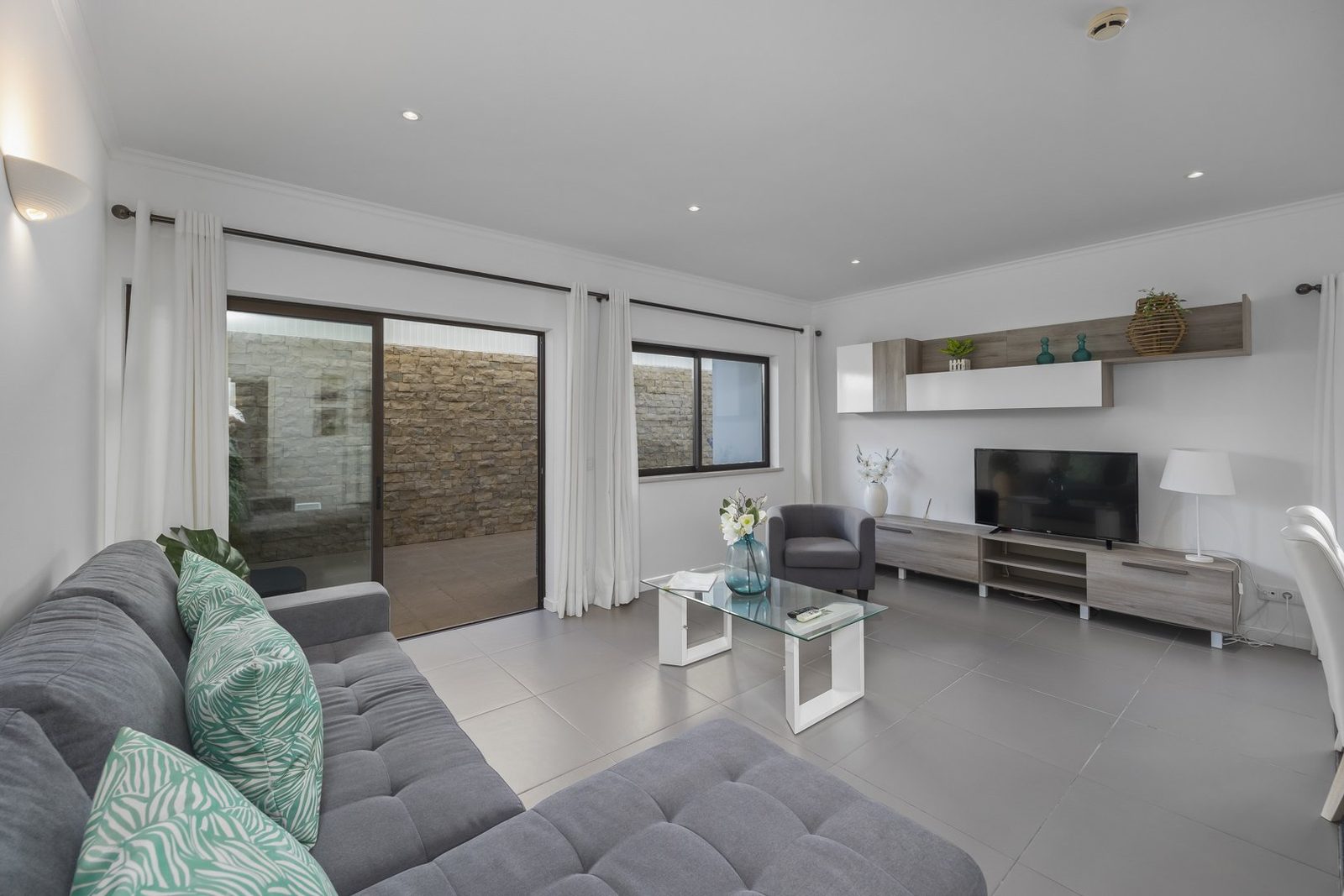 Living room with TV wall unit and terrace access